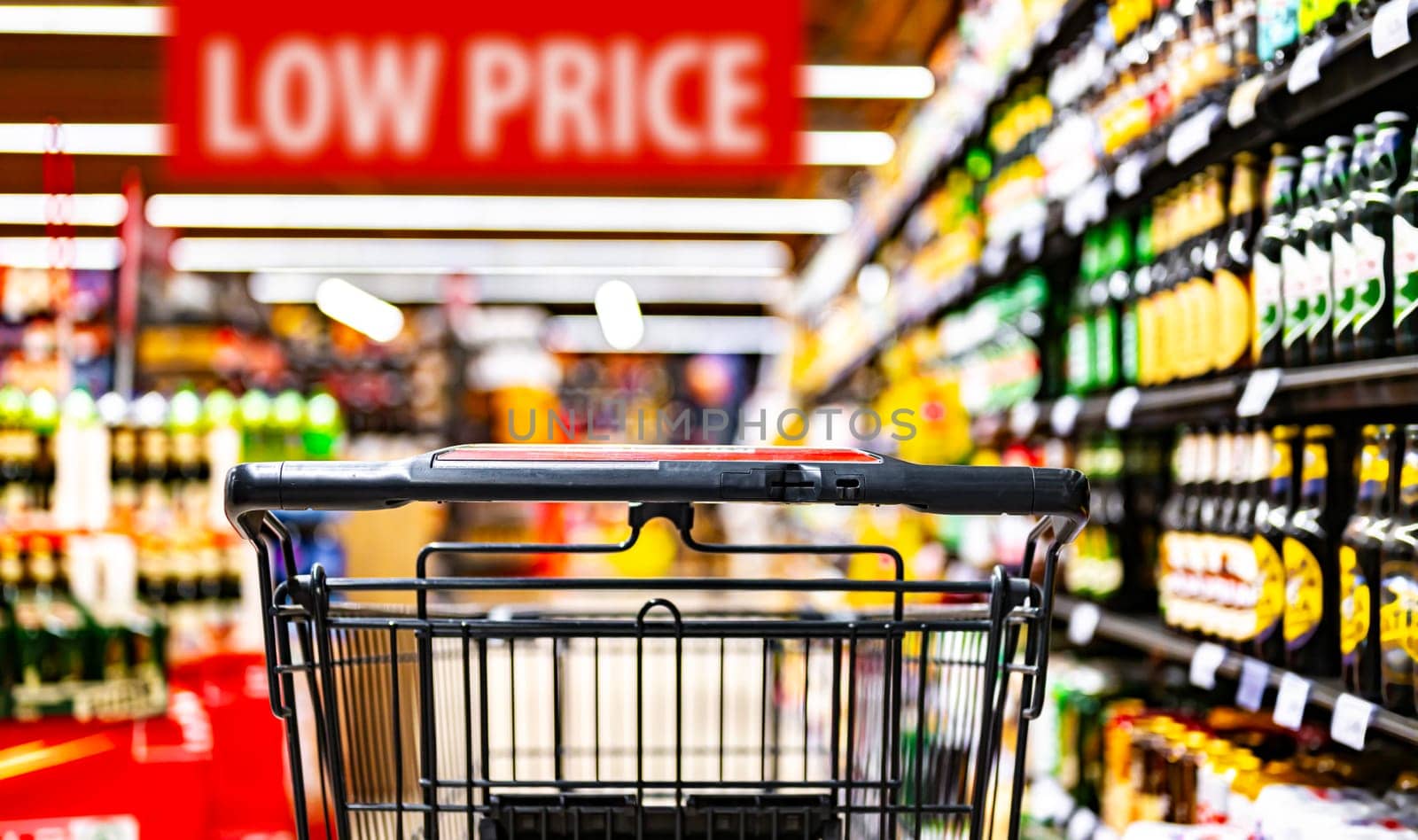 A shopping cart by a store shelf in a supermarket