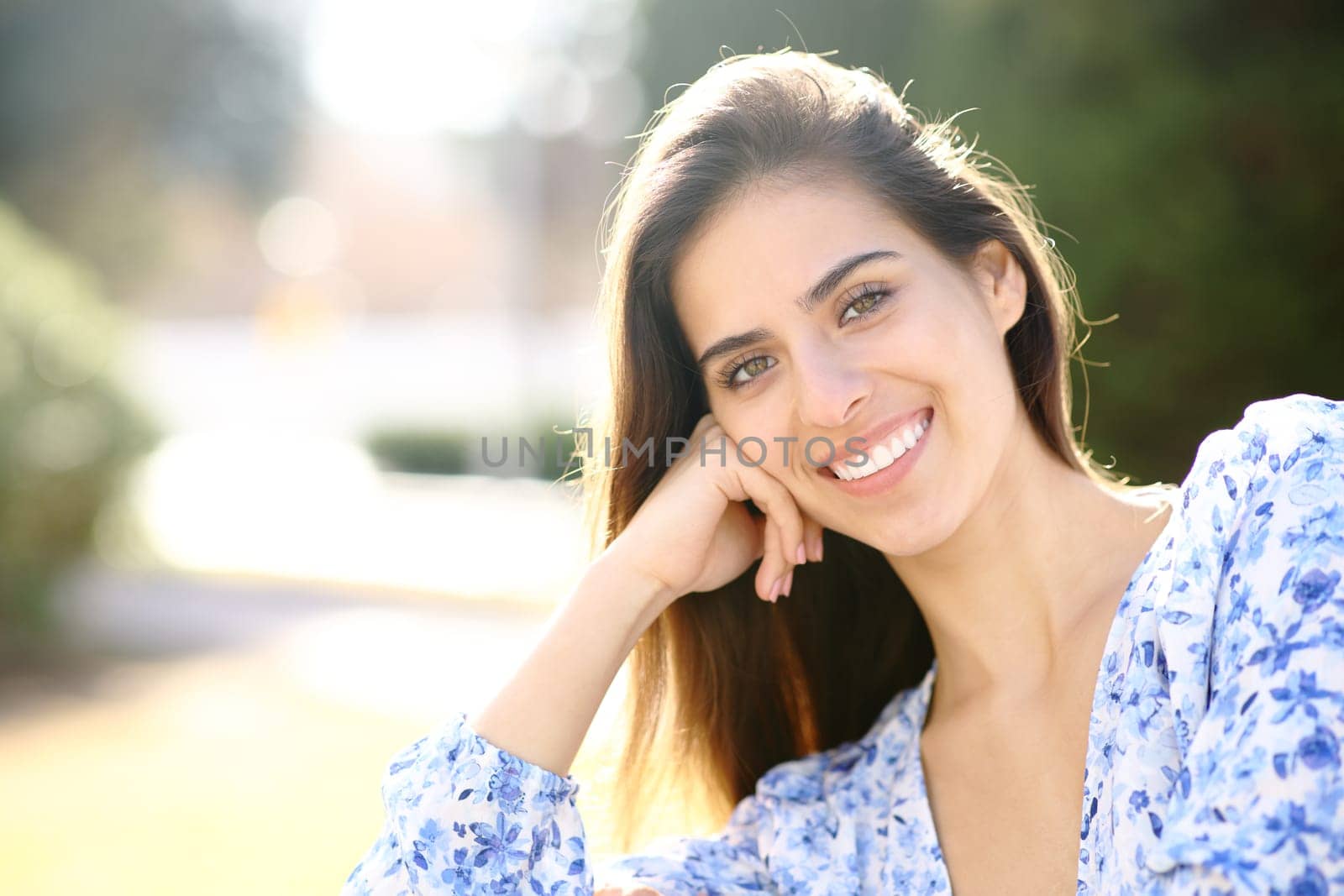 Beauty woman with white smile looks at you in a park