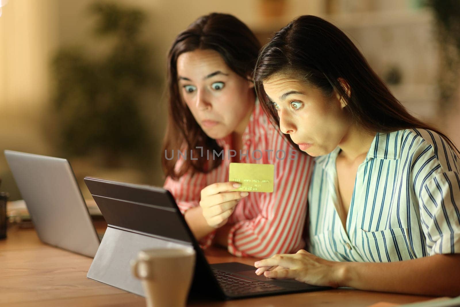 Perplexed tele workers buying online working in the night at home