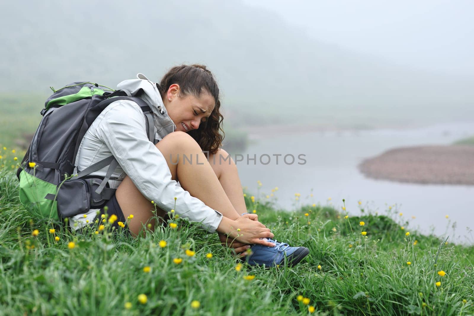 Single hiker suffering ankle ache after strumbling in nature