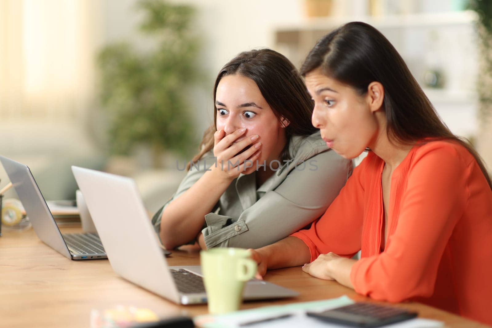Shocked tele workers checking laptop working at home