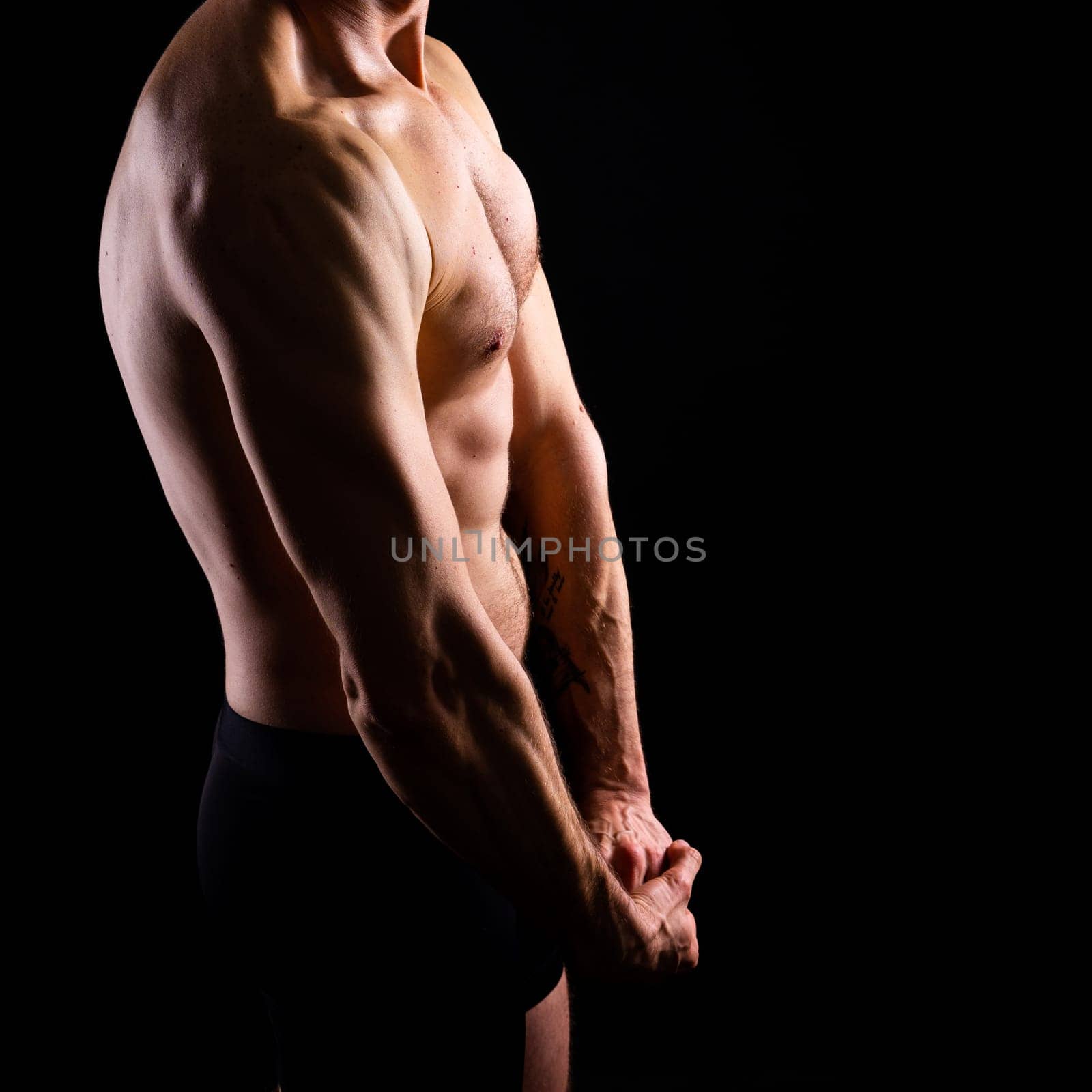 Handsome bodybuldier man posing showing muscle, shirtless torso showing pectorals and sixpacks