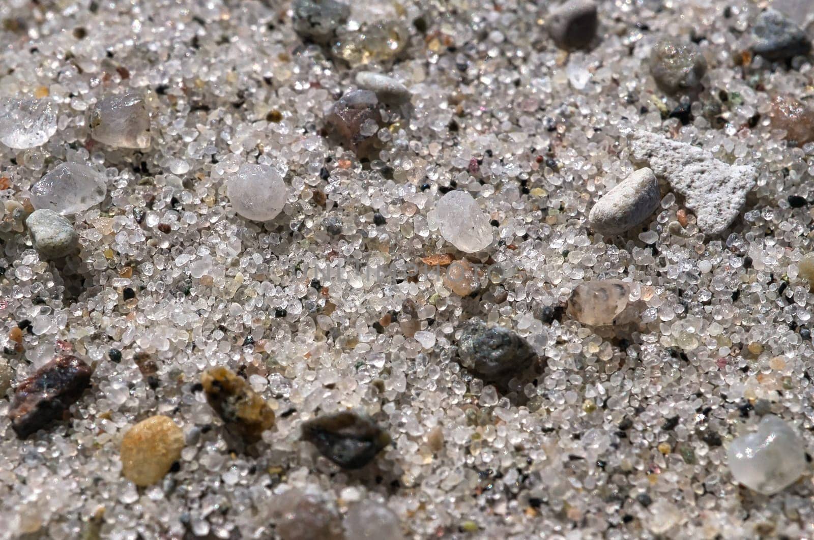 Sand on the beach. Small pebbles in different colors. Detail shot. Landscape on the coast