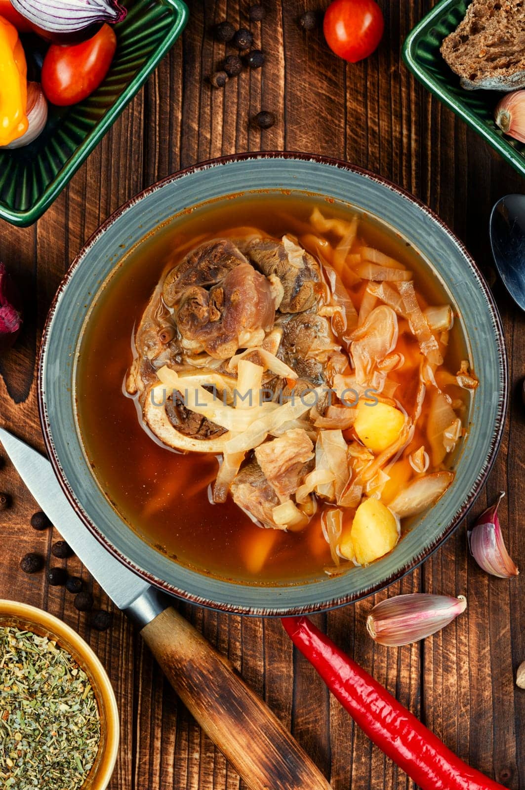 Tasty soup with meat on the table. Traditional Russian borscht on old rustic wooden table. Ukrainian cuisine.
