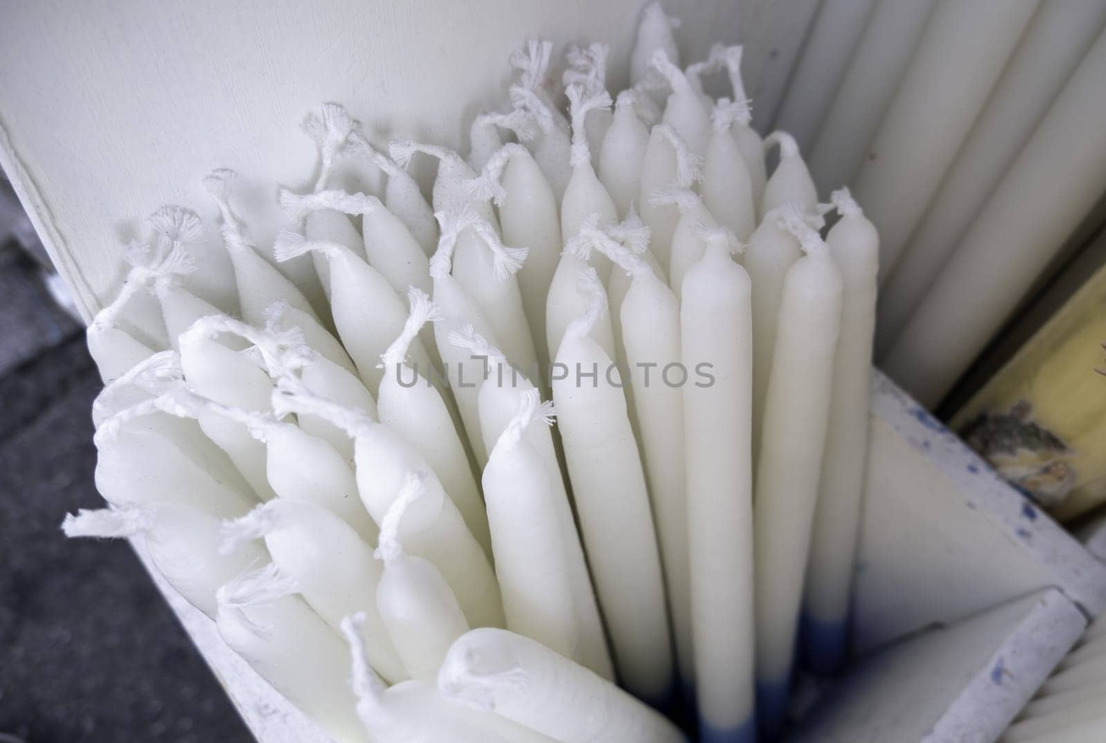 Detail of unlit white wax candle, tradition and faith