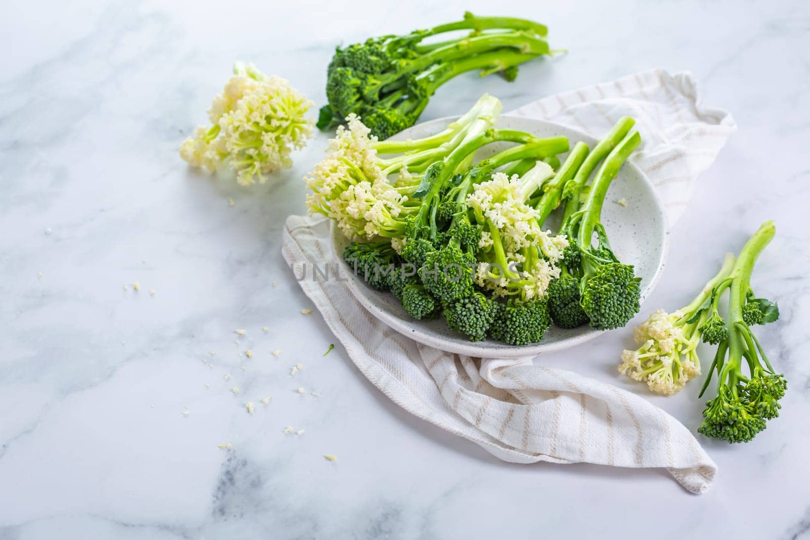 Fresh raw green bimi, broccolini and baby stick cauliflower in a bowl