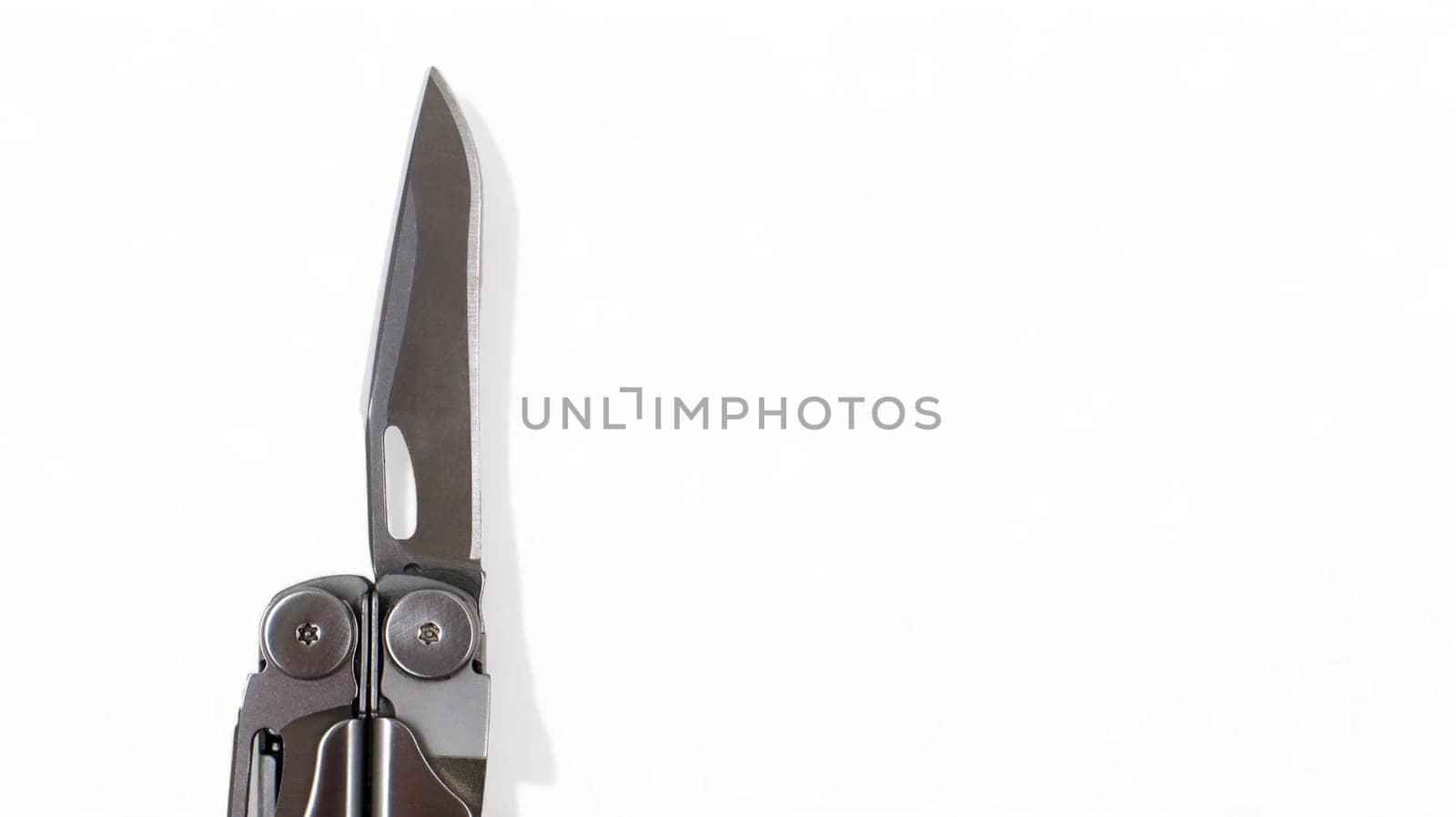 A steel multi-tool with an open knife blade lies on a white background. Pocket open folding knife. Portable multitasking multitool with many tools. EDC concept. A tool for daily practice. All in one