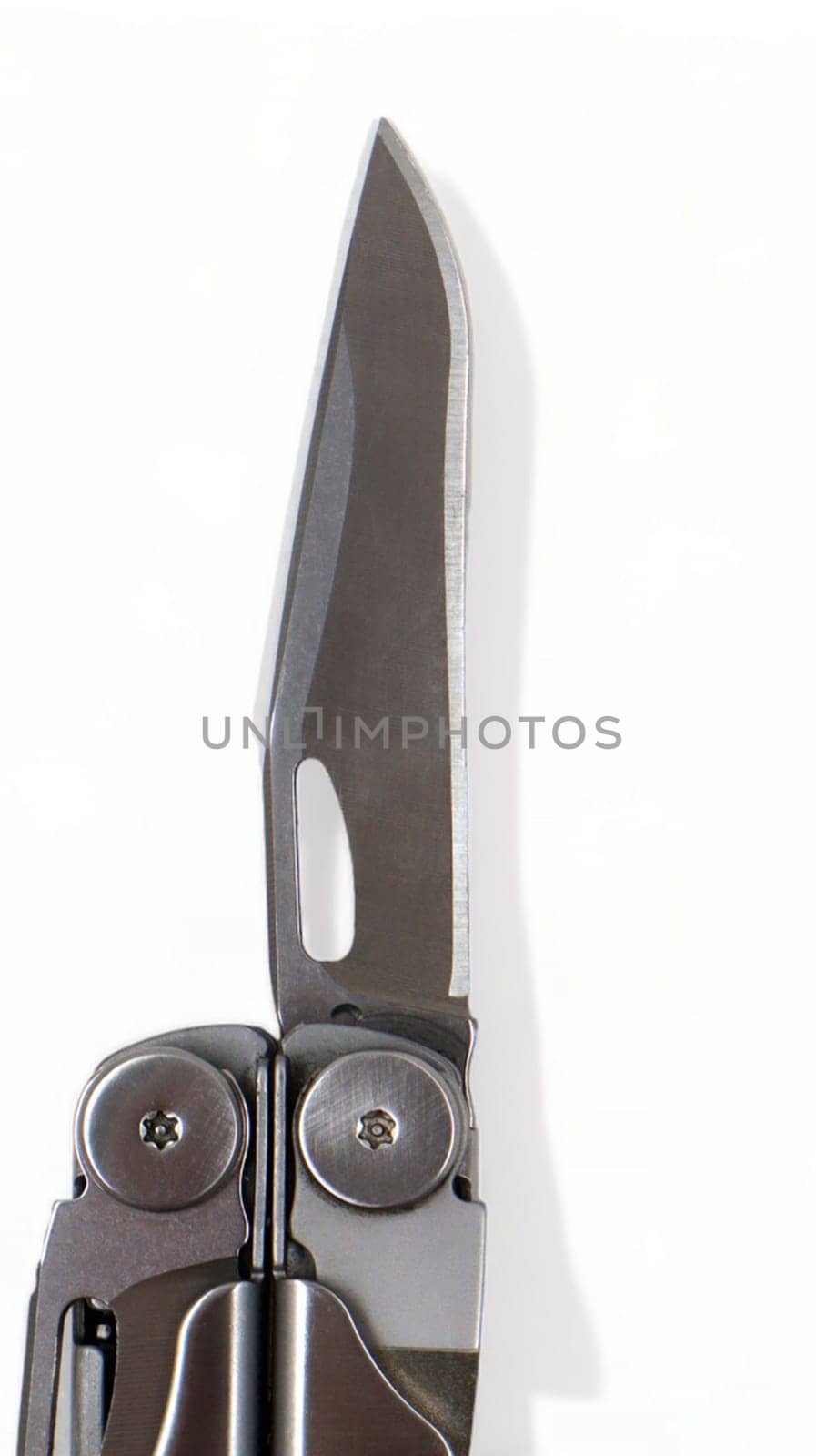 A steel multi-tool with an open knife blade lies on a white background. Pocket open folding knife. Portable multitasking multitool with many tools. EDC concept. A tool for daily practice. All in one