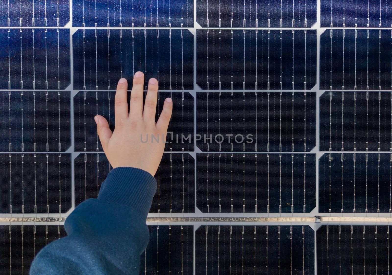 Child boy touching solar panel surface. Environmental education on renewable energies