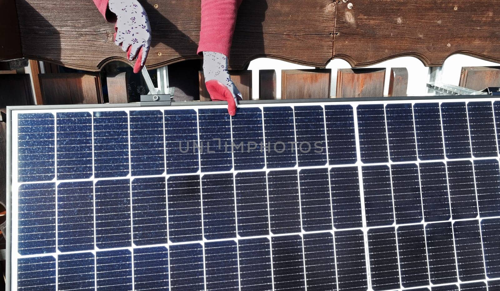 A woman installs a solar system to generate electricity on a balcony