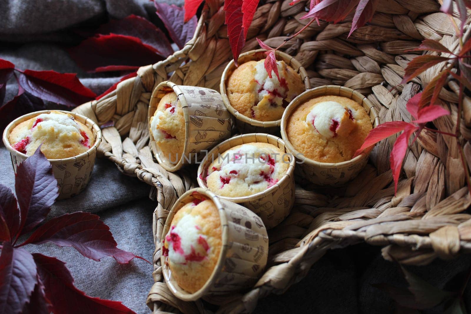 Homemade cupcakes in a star-shaped basket decorated with foliage close-up view from an angle