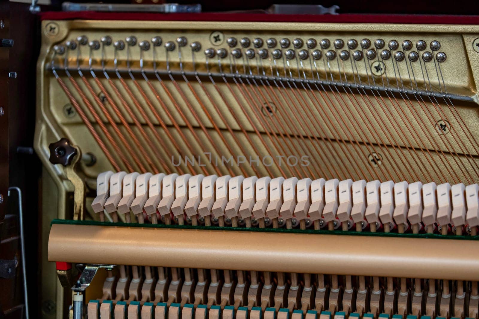 Close-up shallow focus image of the internal mechanisms of an upright piano. It gives a feeling of luxury, beauty, classic, sophistication, elegance. Image can be use for various topics about music.