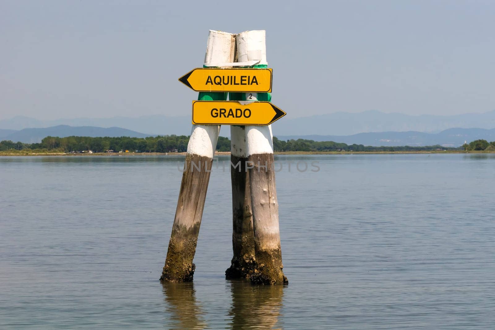 Grado, Italy - June 28th, 2019: Signposts in the lagoon of Grado showing the boat way to the next cities.