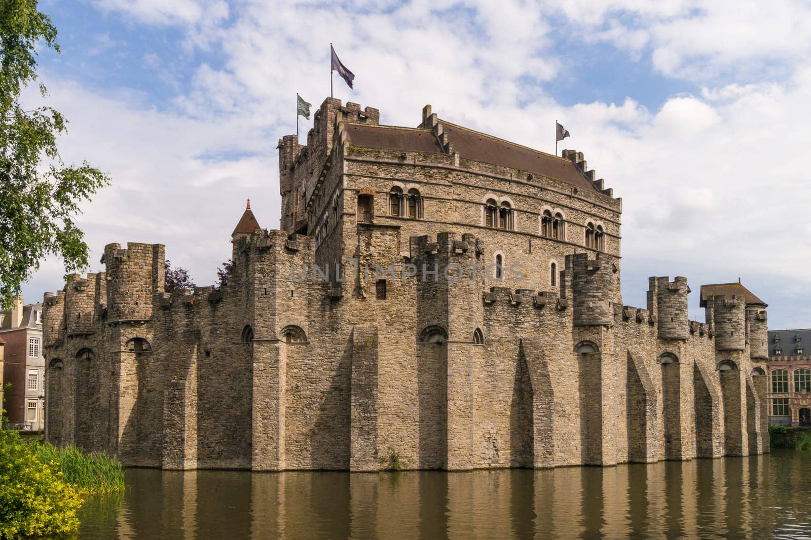 View to the medieval Gravensteen Castle in Ghent surrounded by water