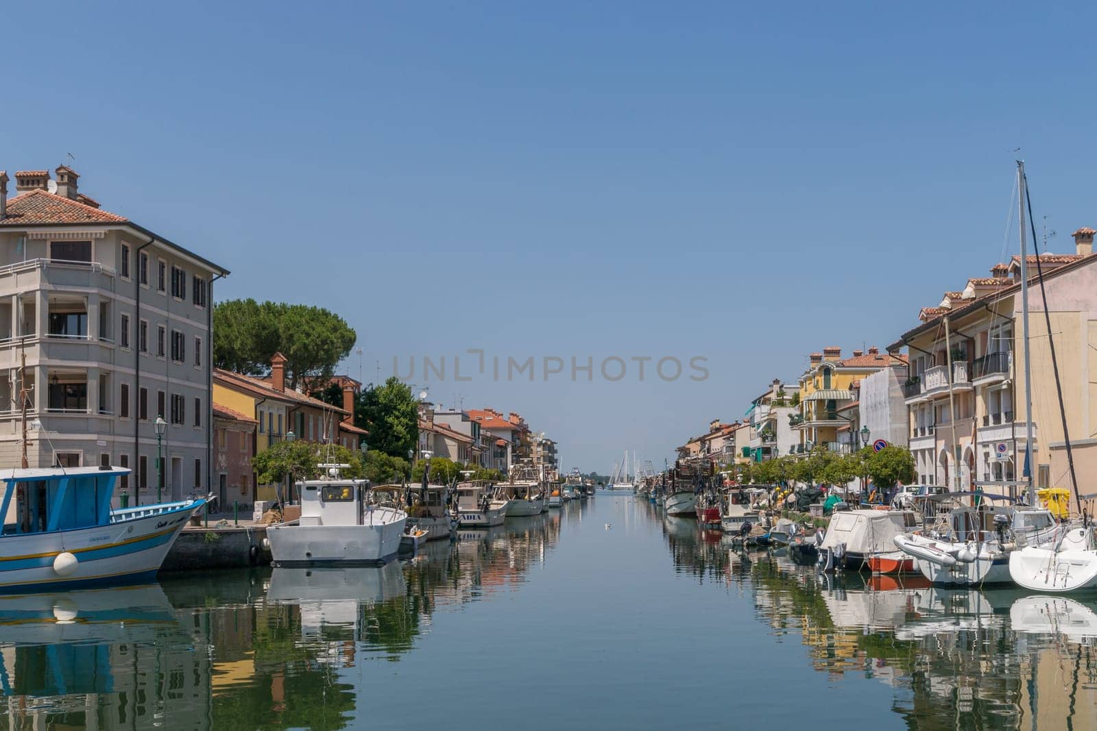 Grado, Italy - June 28th, 2019: View along one of the water alleys of the island city of Grado.