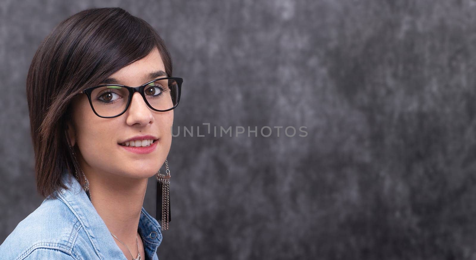Portrait of a smiling happy woman wearing glasses,a  grey background