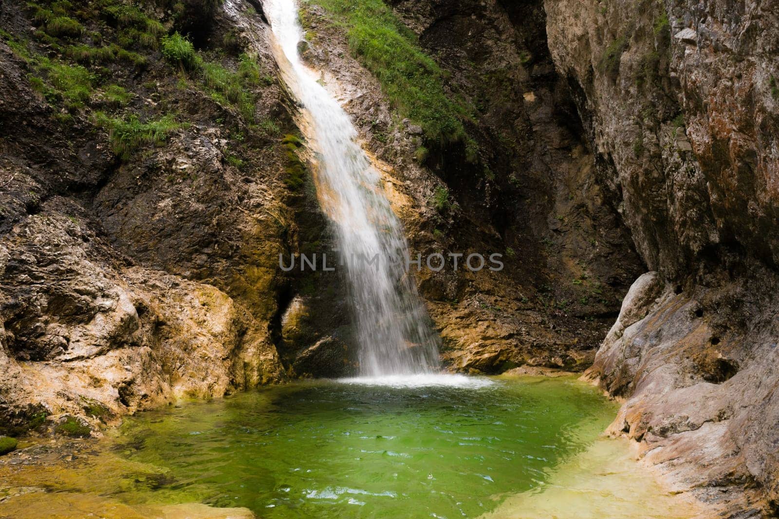 One of the hidden Zapotok waterfalls in upper Trenta Valley in Slovenia, formed by the playful Suhi Potok stream, offers a nice but fresh little swimming pool.