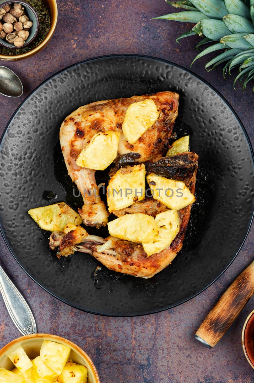 Tasty chicken legs fried with pineapple slices. Barbecue chicken meat on a plate.