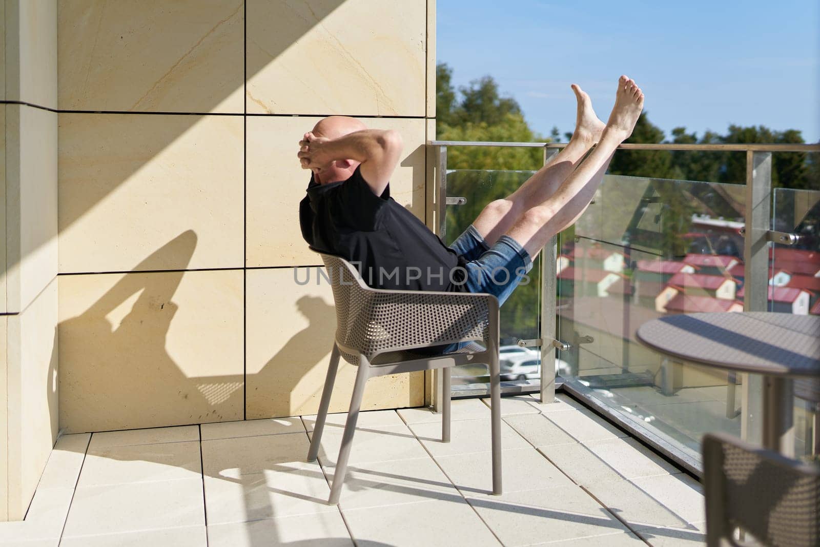 a completely relaxed vacationer sits on the balcony and enjoys the peace and quiet and the view