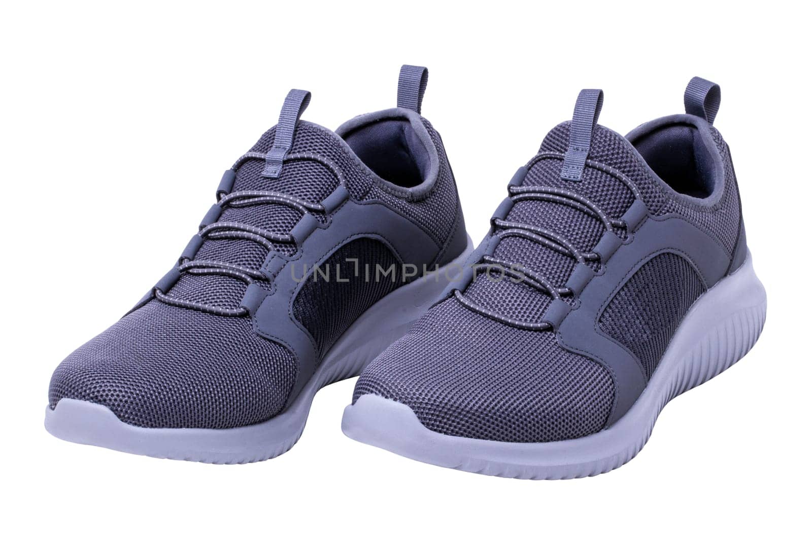 Closeup of a pair of modern silver gray sneakers or sports shoes isolated on a white background. Clipping path. Elegant and trendy mans shoes. Macro.