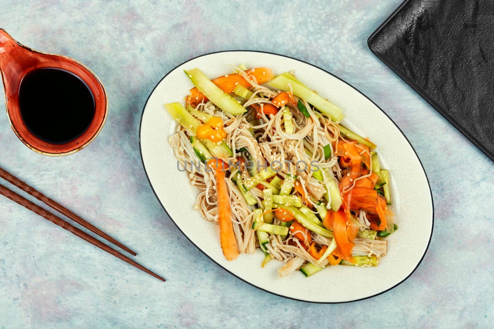 Plate with salad of enoki mushrooms or needle mushroom and vegetables. National Chinese food.