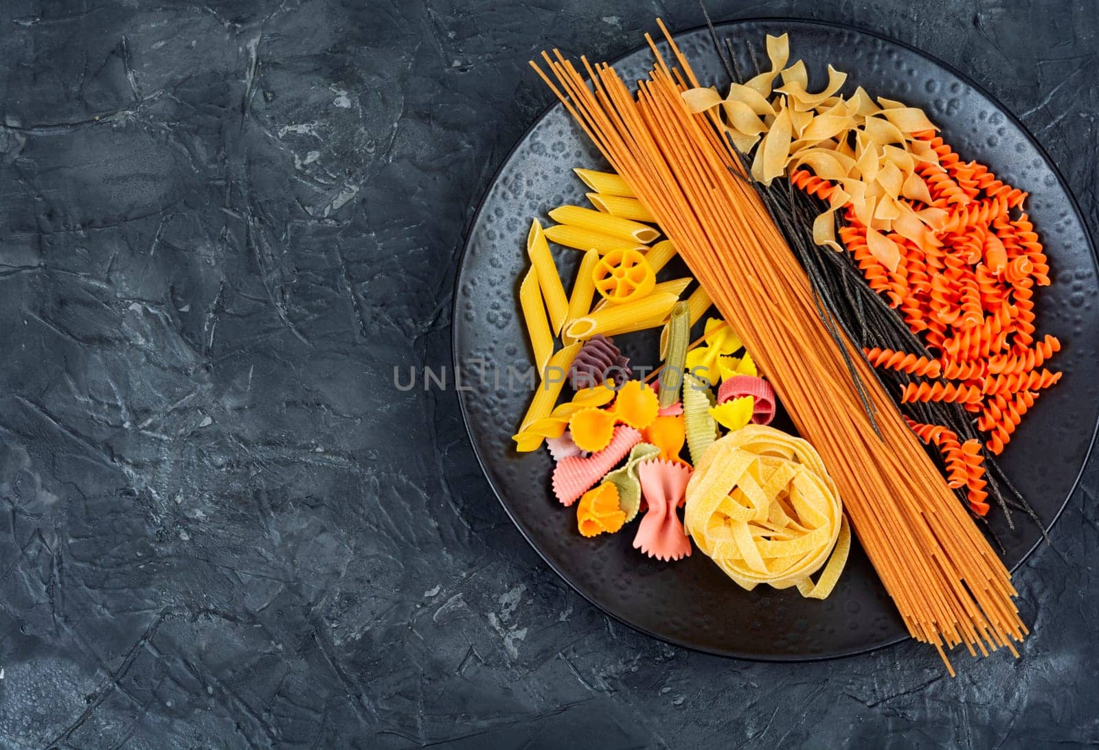 Different sorts of uncooked pasta, macaroni, noodles and spaghetti. Copy space.