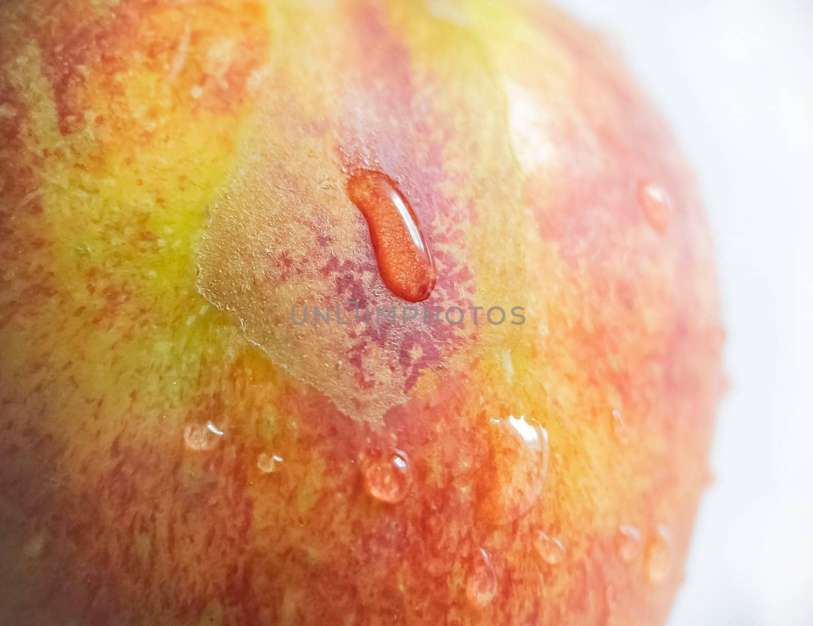 A red-yellow apple with water droplets on the surface.Texture or background.Macro