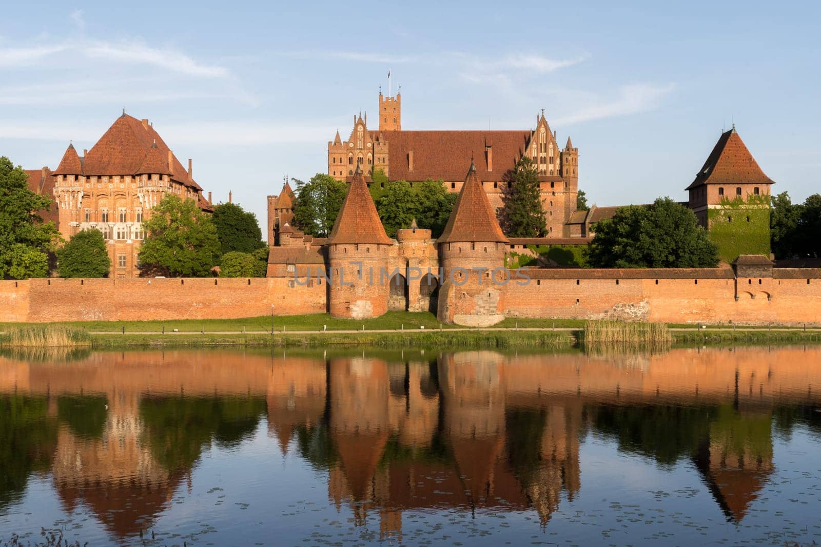Beautiful view over the river to the worlds largest castle by area, the medieval Malbork Castle in Poland.