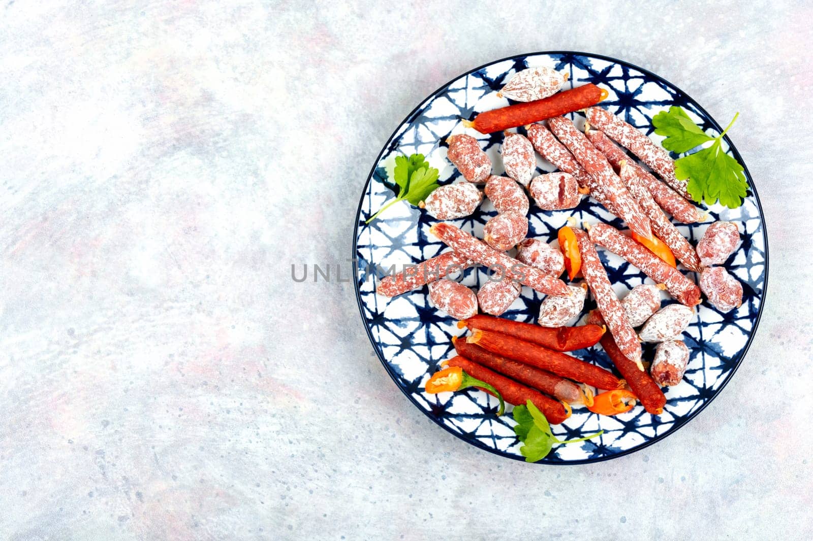 Three varieties of salami sausage on a plate, meat appetizer. Copy space.