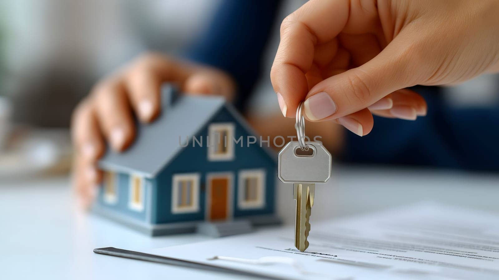 Hands of salesman holding key near house model and paper document on table. Neural network generated image. Not based on any actual person or scene.
