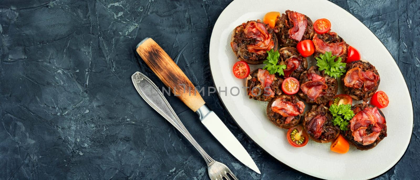 Homemade champignon mushrooms stuffed with minced meat and bacon. Copy space.