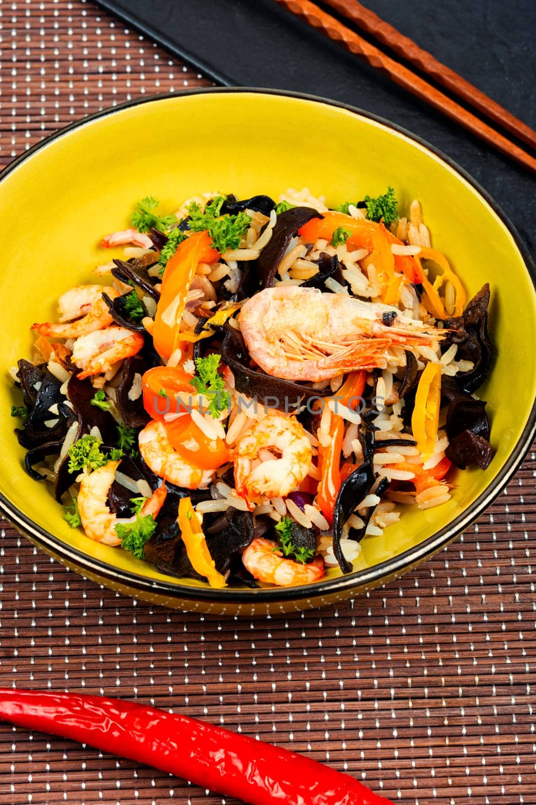 Traditional Chinese food, fried rice with shrimp or prawns and mushrooms on a vintage wooden background..