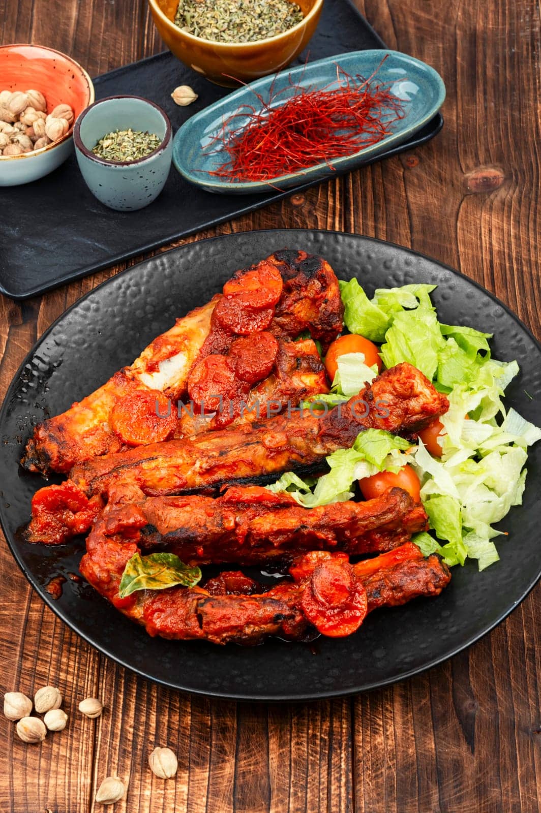 Braised or stewed pork ribs in tomato sauce on old rustic wooden table. Ready for eat.