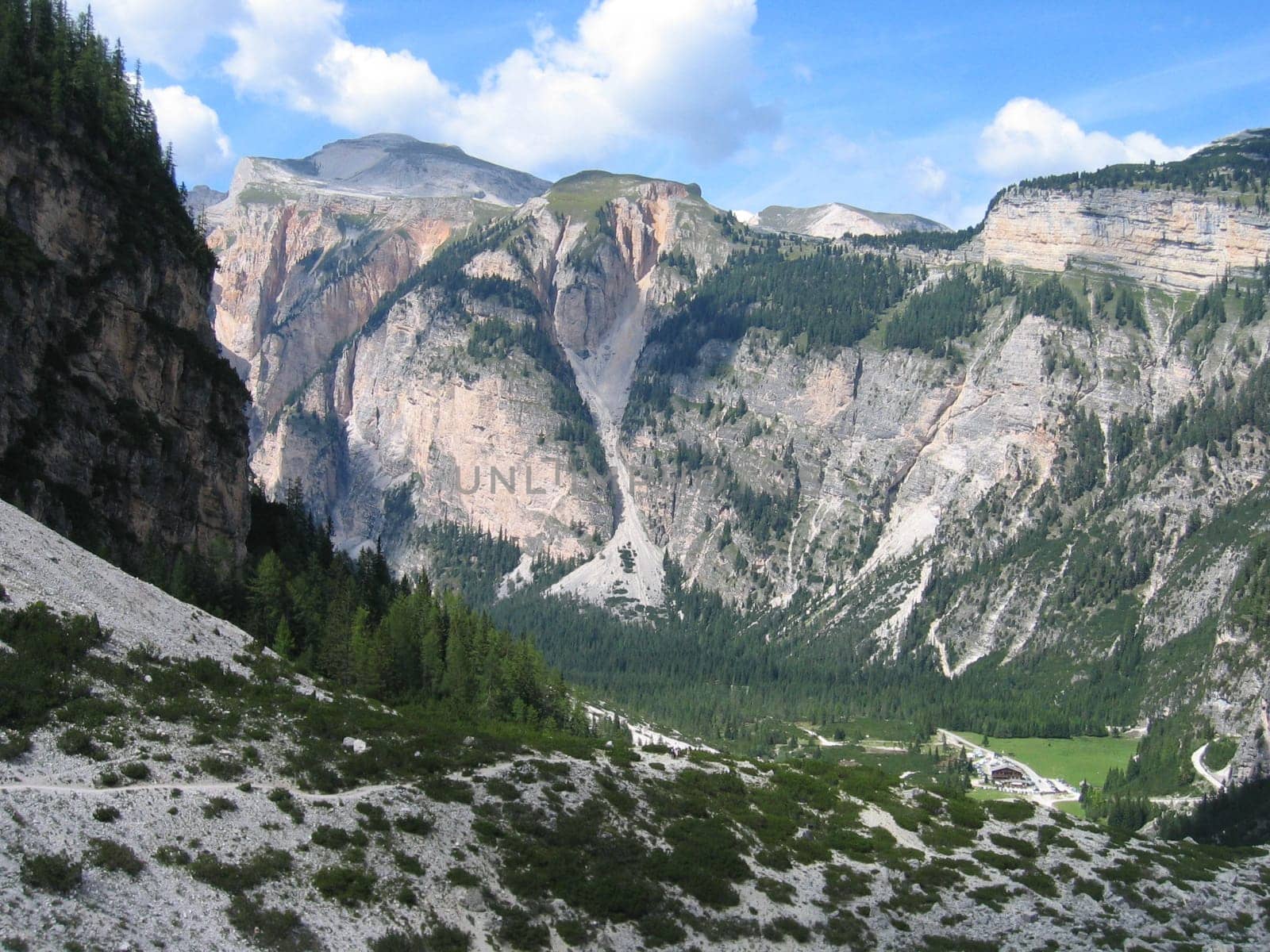 scenic view to the snow capped dolomites and the green landscape in the Alps, Italy
