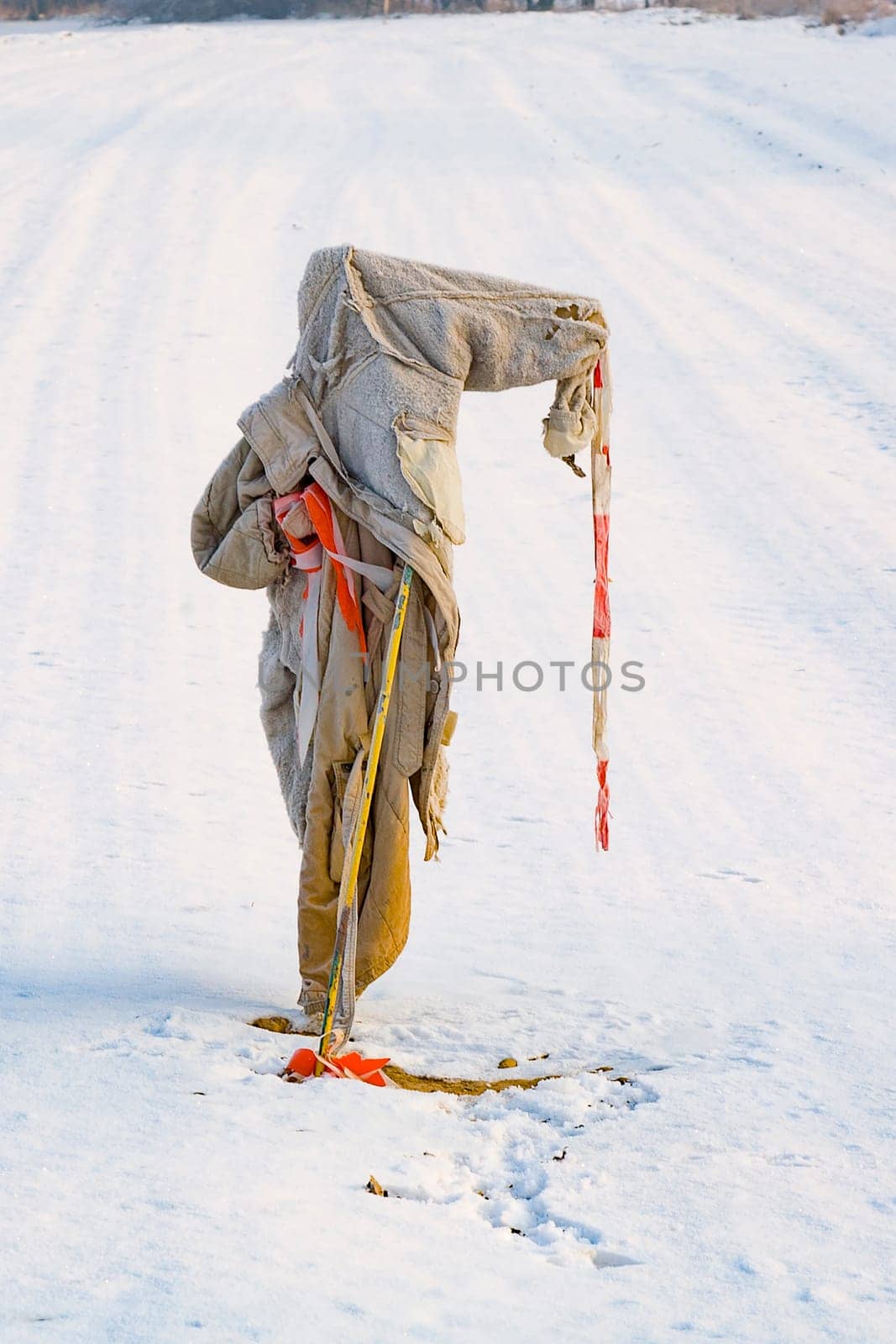 sad, ragged  and freezing scarecrow in winter on the snowfield