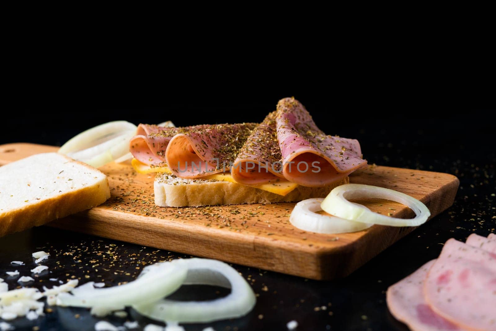 Slices of sausage Mortadella and onion on a cutting board