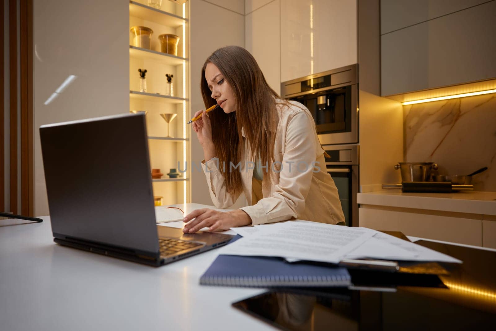 Woman using laptop making research working or studying online from home. Concentrated attractive female freelancer learning web classes or having virtual call business meeting