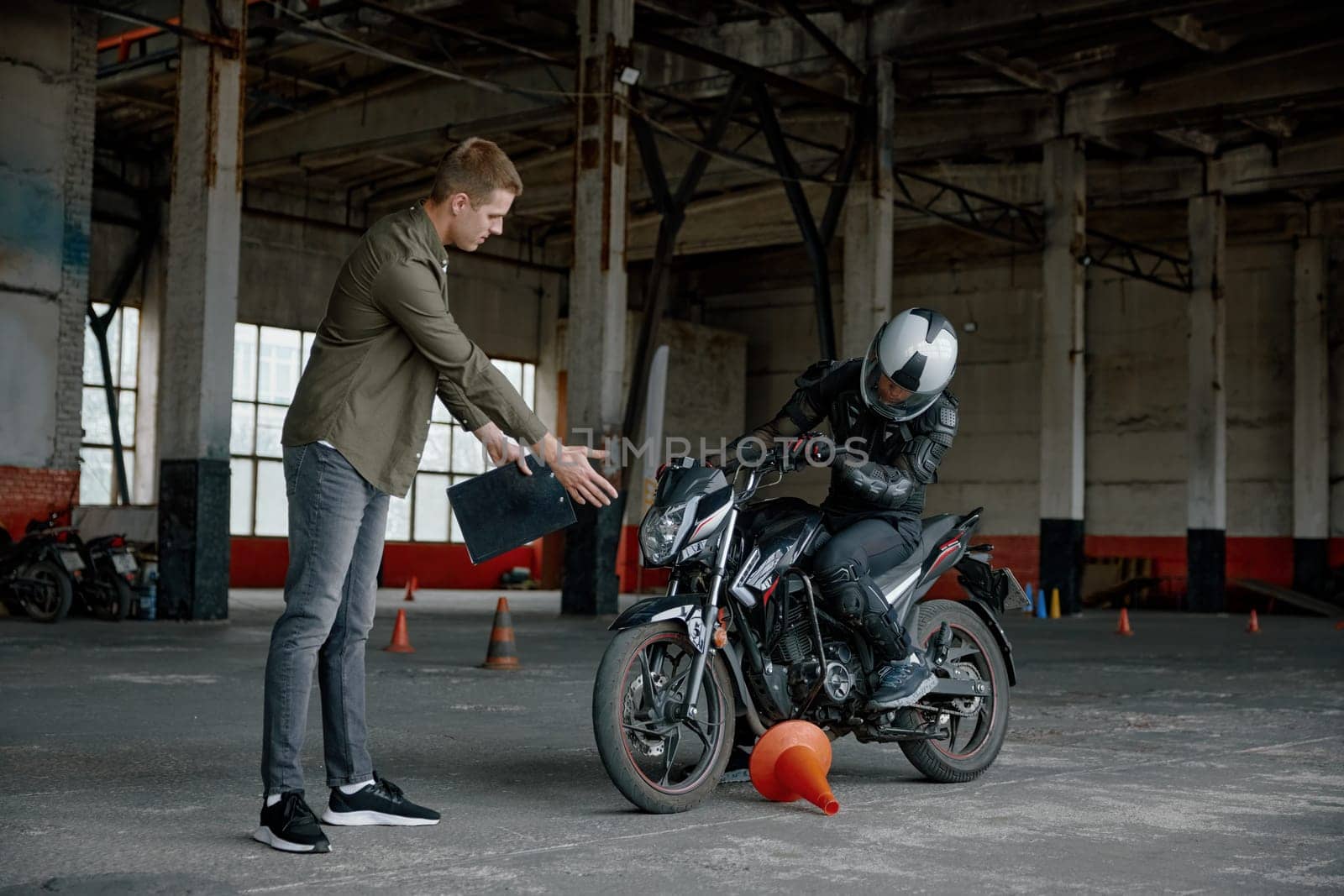 Man motorcyclist making mistake touching cone during personal riding class at school. Examination on driving license
