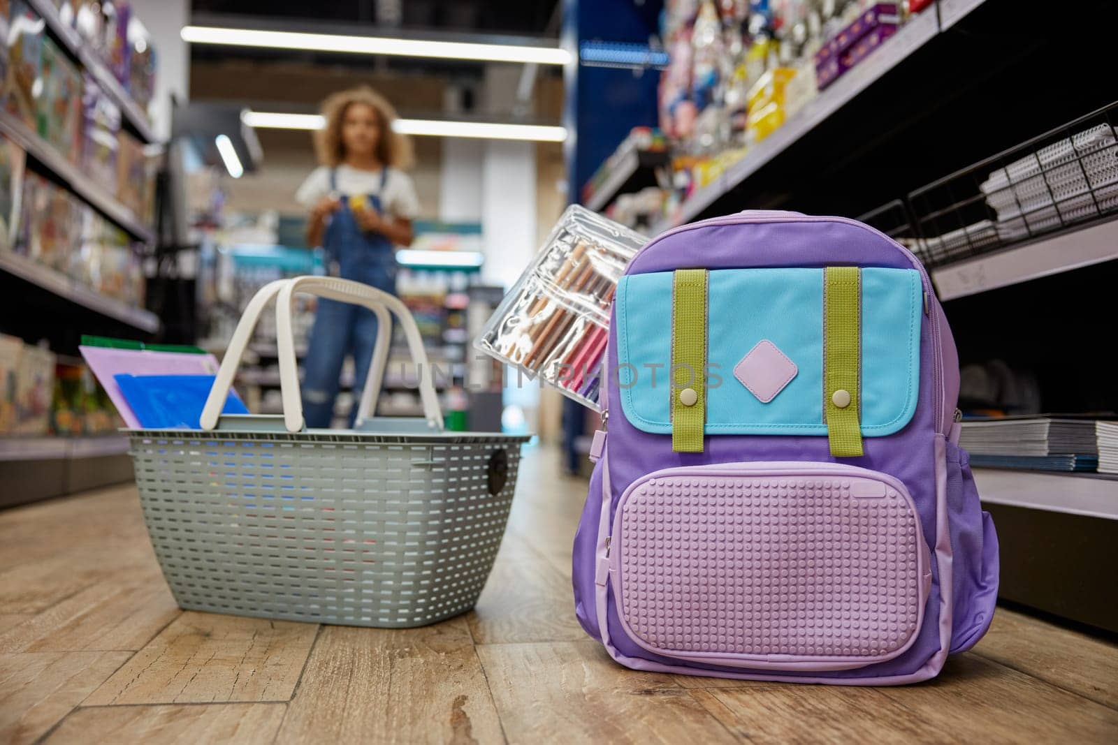 School supplies shopping at stationery store with focus on personal belongings school bag and basket of young female student on blurred background. Great sale choice for study accessories