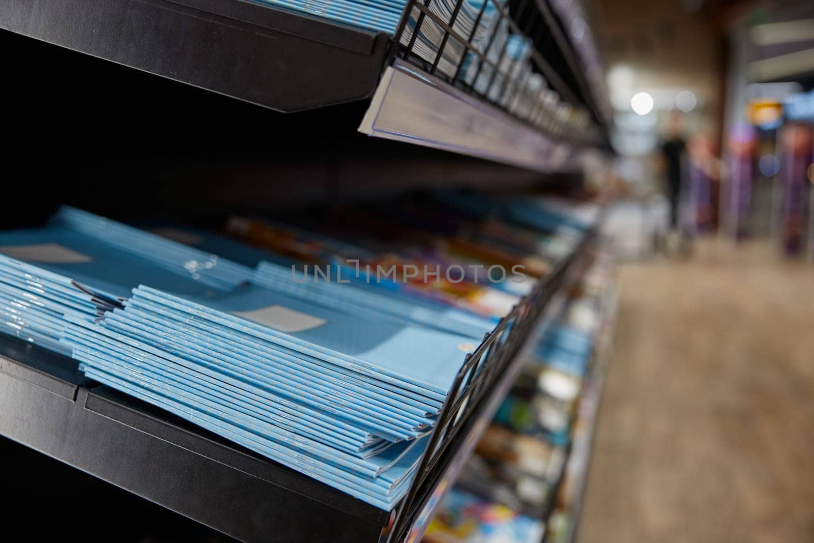Stationary shop rack with paper copy-books assortment selective focus. Retail place showcase with studying supplies. Best prices for education preparation