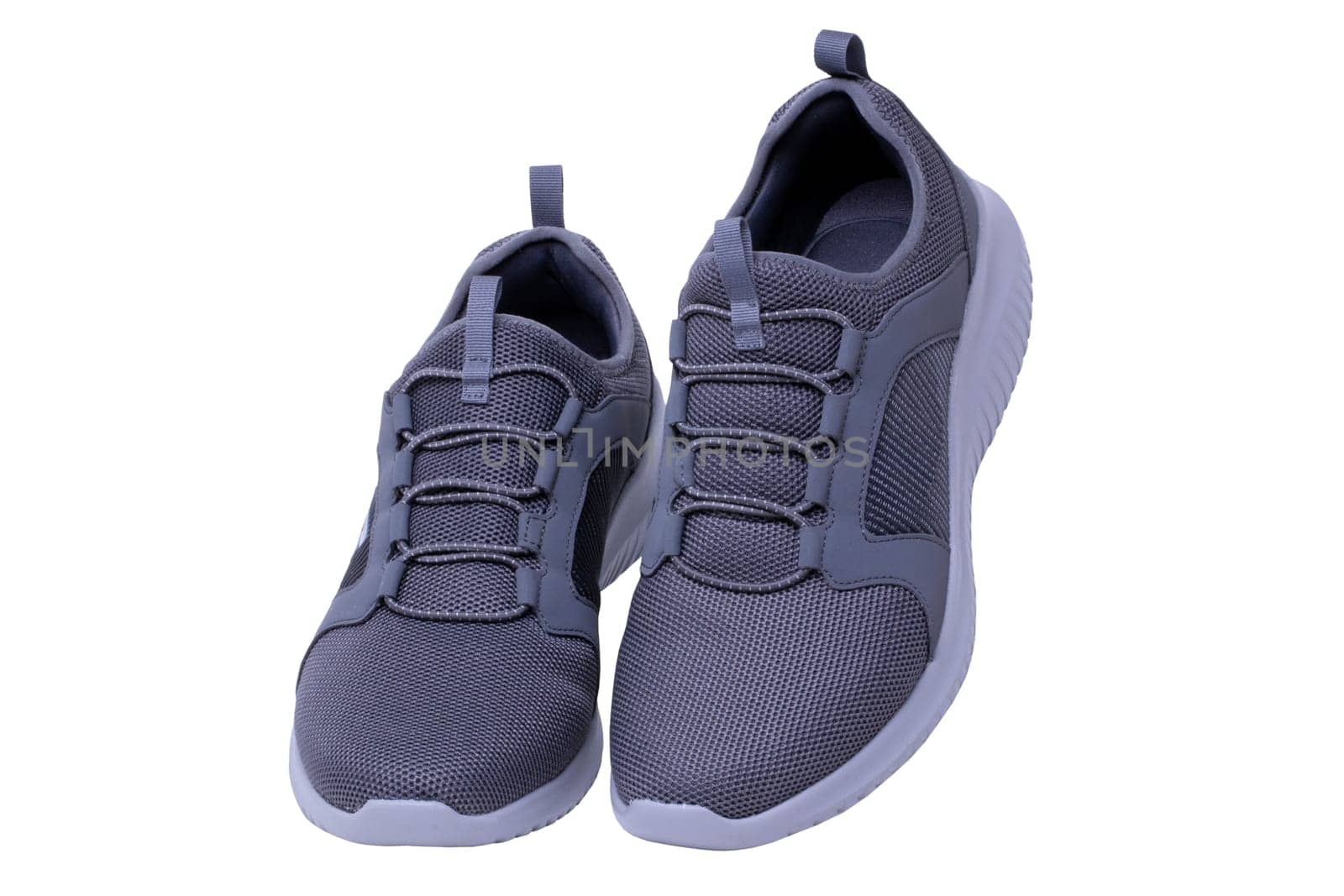 Closeup of a pair of modern silver gray sneakers or sports shoes isolated on a white background. Clipping path. Elegant and trendy mans shoes. Macro.