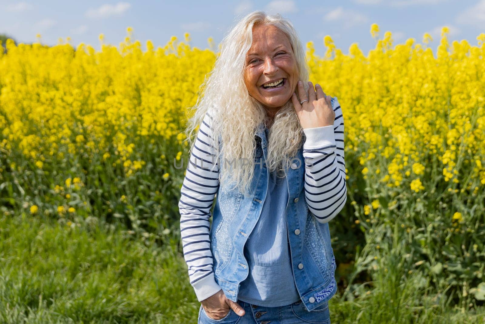 Happy woman in front of a blooming rapeseed field