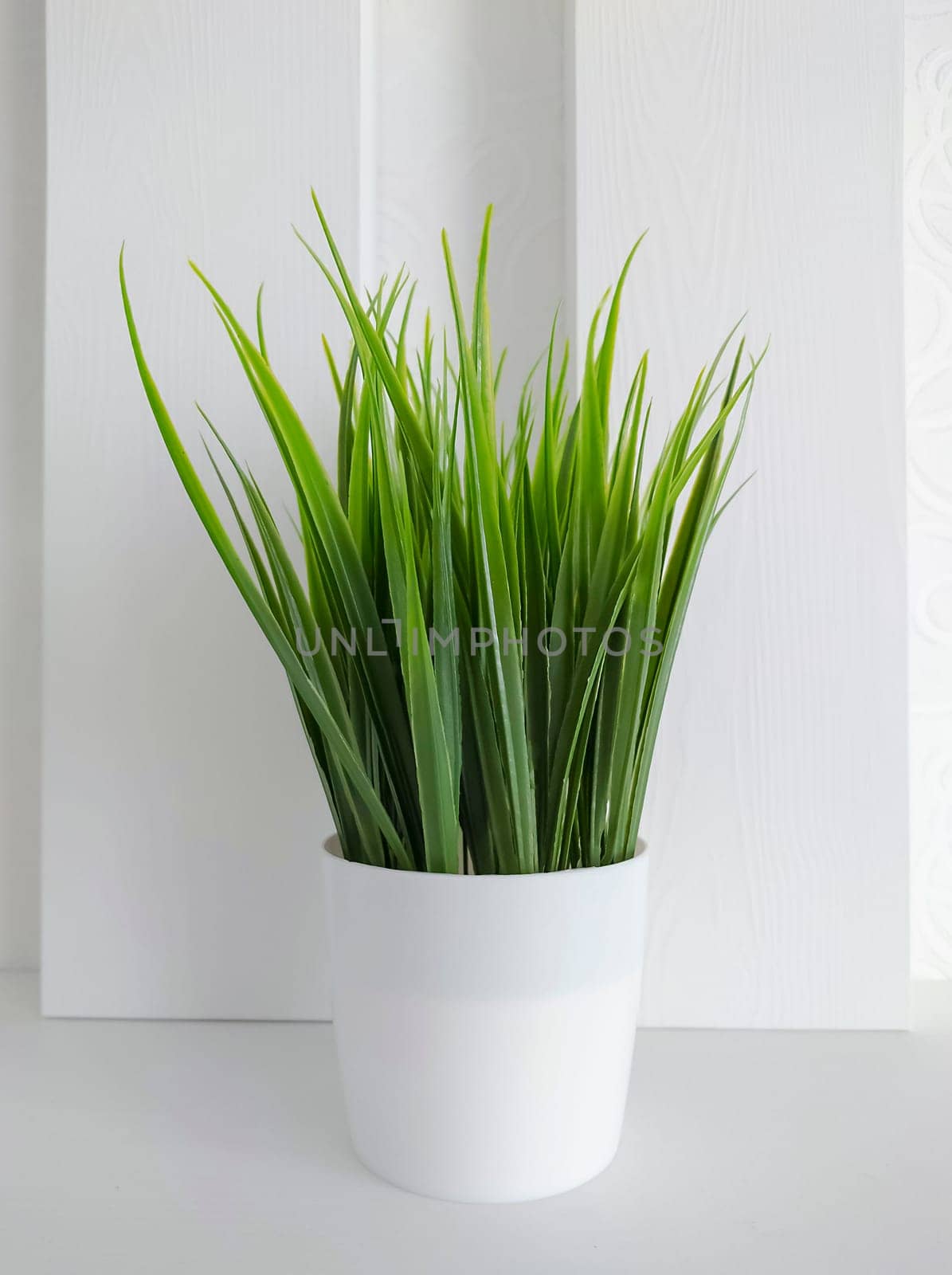 Texture or background.Decorative artificial grass of green color in a pot for interior and design