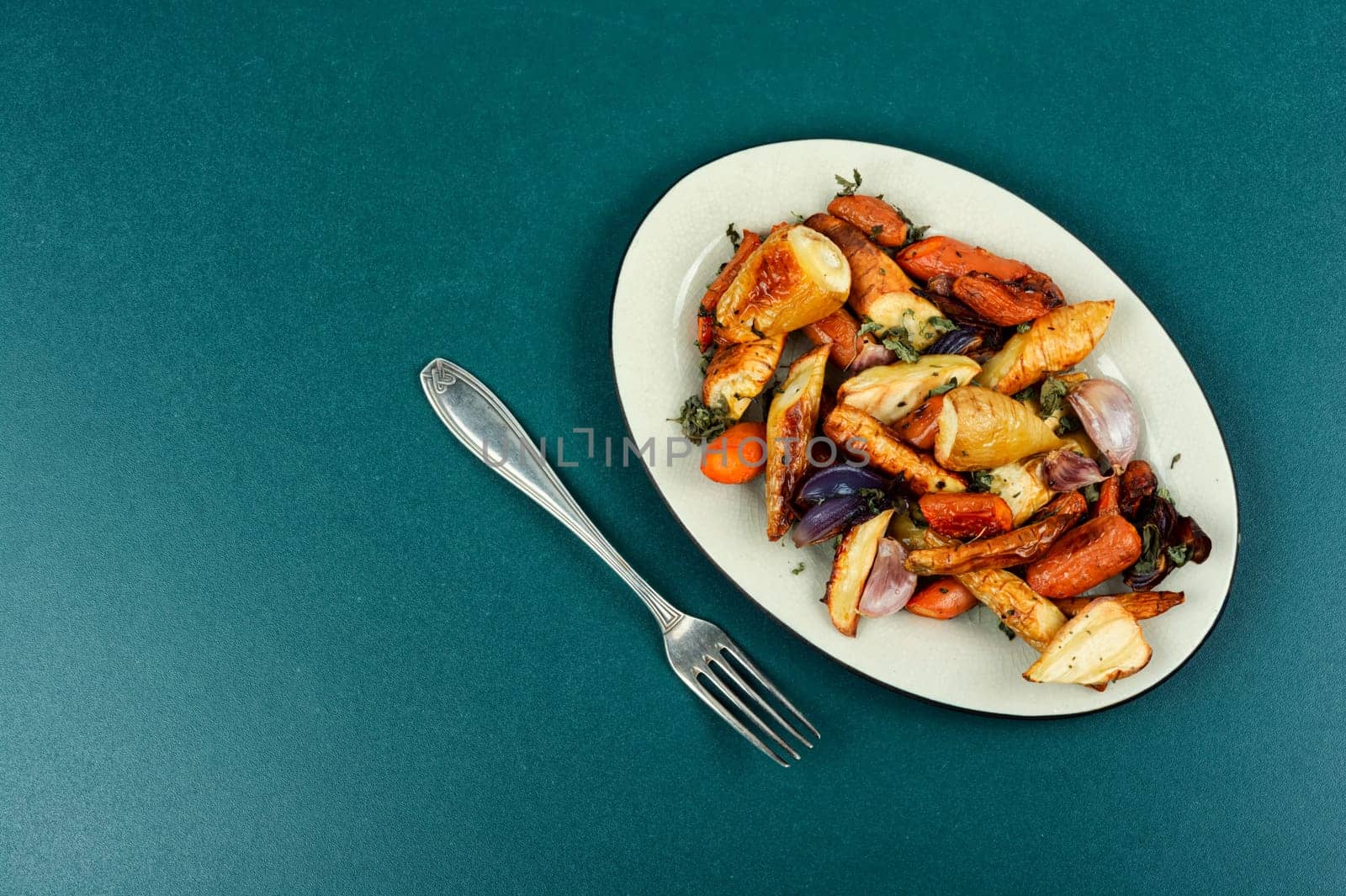 Winter garnish of baked parsnip root, carrots and garlic. Copy space.