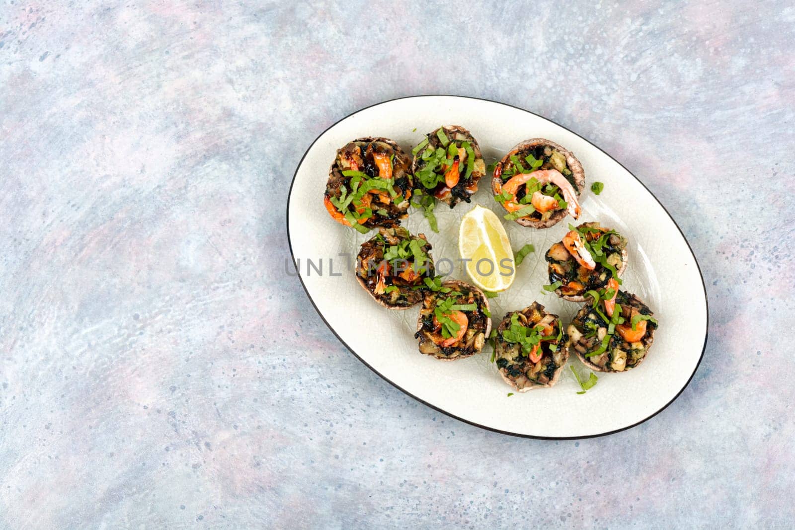 Champignon mushroom caps baked in the oven with prawns.