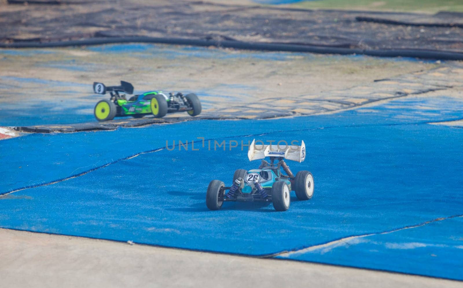 Merida, Spain - Jan 28th, 2024: Extremadura 1/8tt gas Championship RC Car. Cars making a curve over blue turf