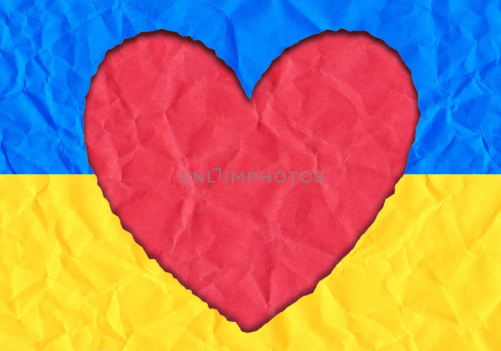 Scrap of paper in the shape of a heart in the colors of the Ukrainian flag, copy space