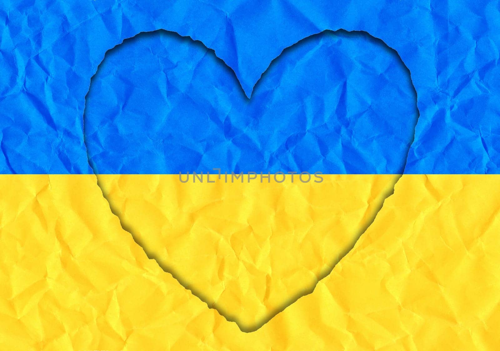 Scrap of paper in the shape of a heart in the colors of the Ukrainian flag, copy space