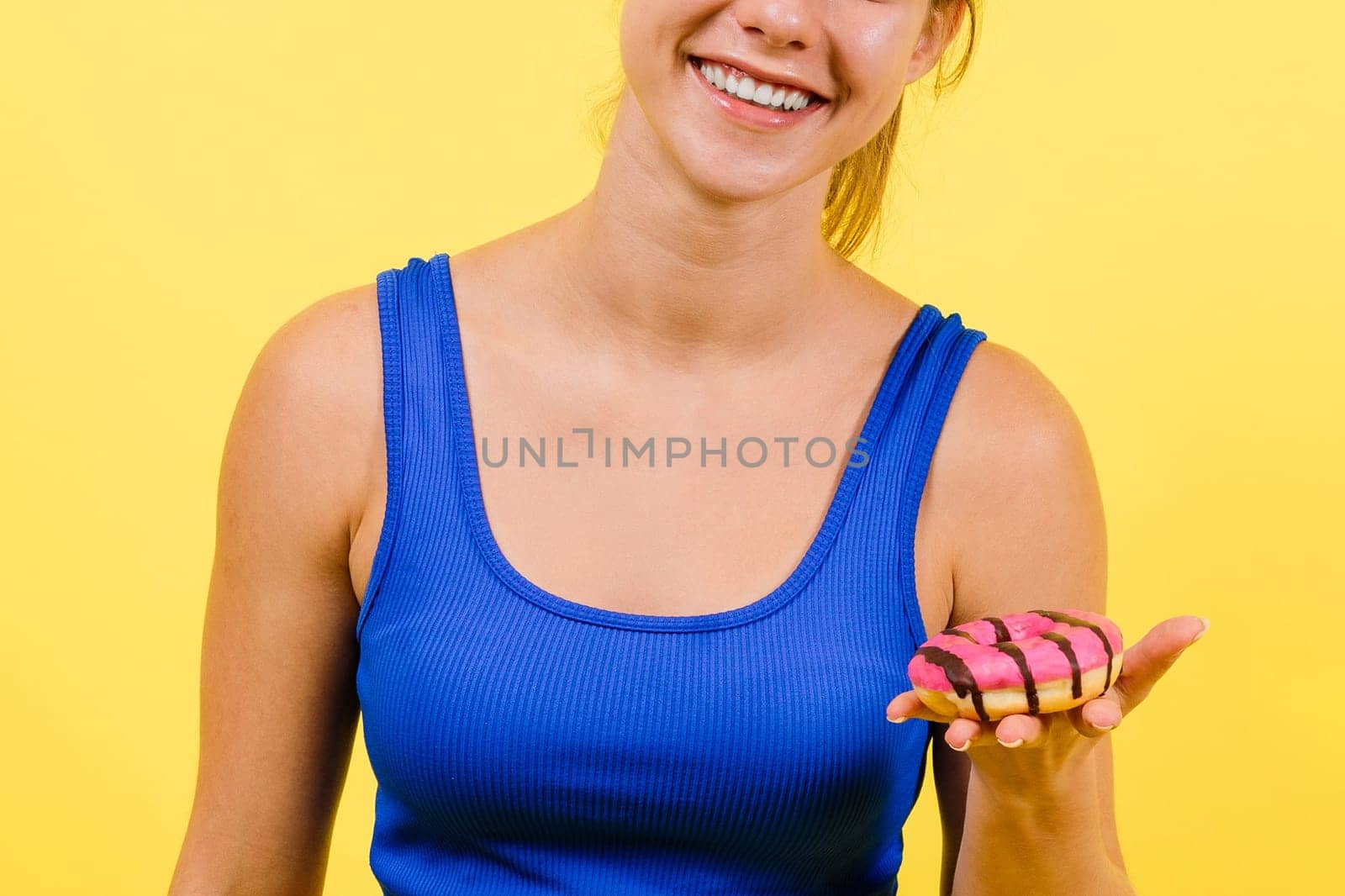 Portrait of beautiful female with chocolate donuts enjoying and looking at the camera