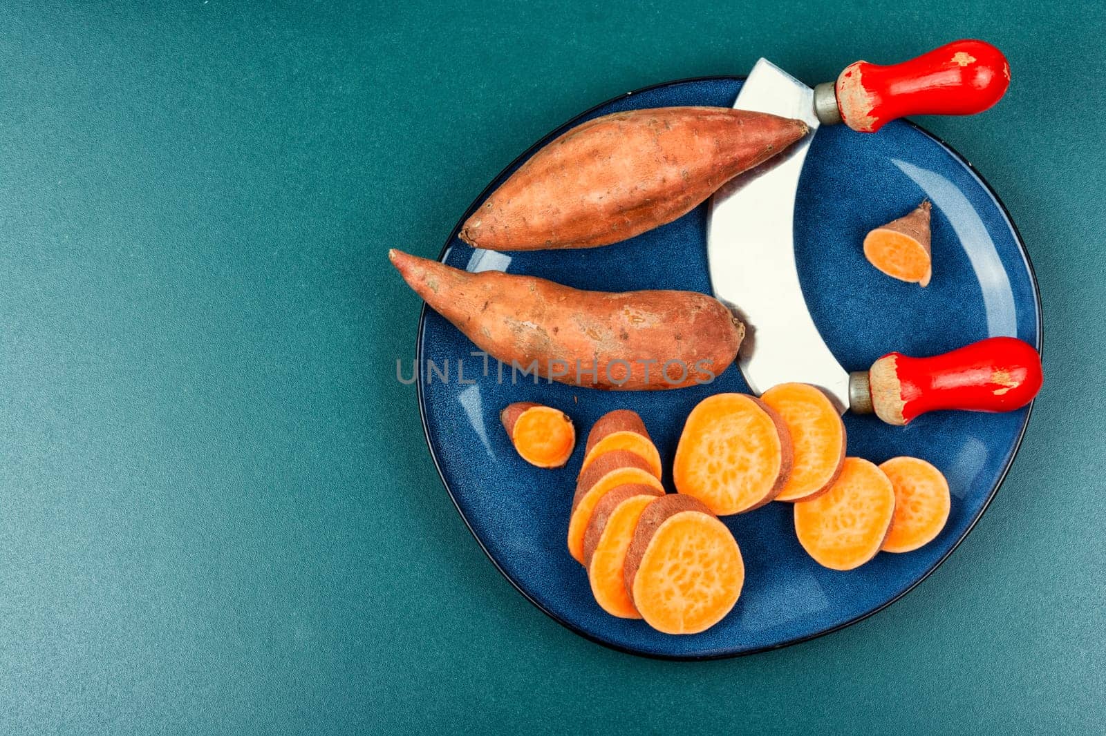 Raw sweet potatoes or batatas. Yam on concrete kitchen table. Dietary food. Space for text.